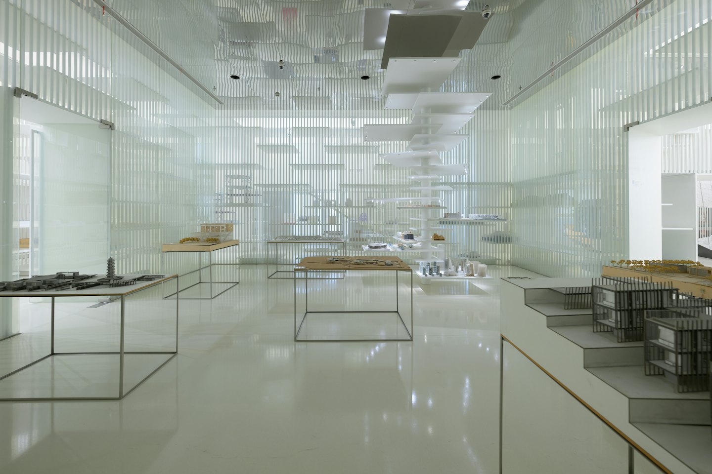Spazio espositivo moderno con oggetti di design su tavoli espositivi.